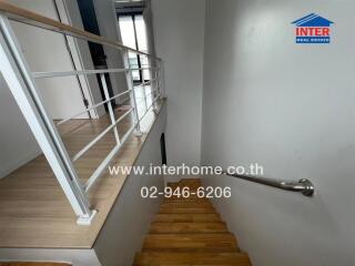 Staircase inside the building with wooden steps and white walls