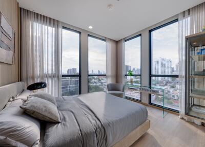 Modern bedroom with large windows and city view