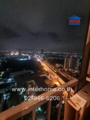 Night view of a cityscape from a balcony or window with visible traffic and high-rise buildings