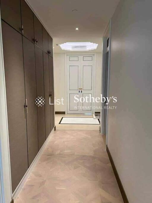 A hallway with built-in cupboards and a view of a doorway