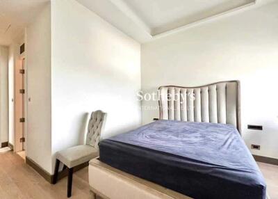 Bedroom with a tufted headboard and a chair