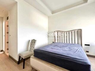 Bedroom with a tufted headboard and a chair