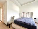 Bedroom with a tufted headboard and a chair