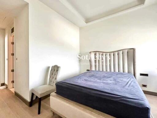 Bedroom with a tufted headboard and a chair