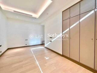 Bright bedroom with wooden flooring and built-in wardrobes