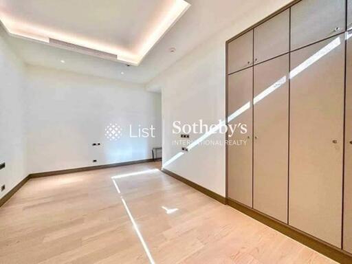 Bright bedroom with wooden flooring and built-in wardrobes