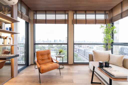 Modern living room with city view, armchair, sofa, and decor