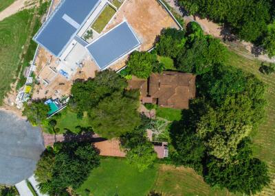 Aerial view of a property with buildings and surrounding greenery