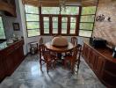 Dining room with wooden furniture and large windows