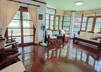 Spacious living room with wooden floors and large windows