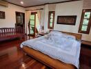 Spacious master bedroom with wooden floors and a large bed