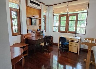 Home office with two desks, air conditioning, and large windows