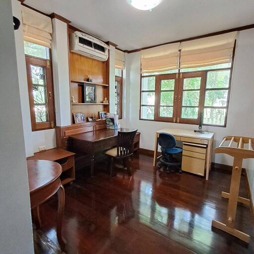 Home office with two desks, air conditioning, and large windows