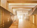 Modern building hallway with illuminated wooden paneling and tile flooring