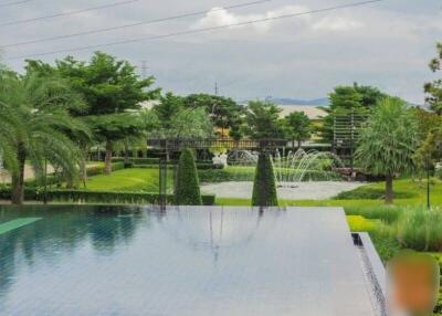 View of garden with decorative pond and swimming pool