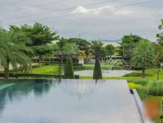 View of garden with decorative pond and swimming pool