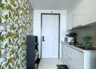 Modern kitchen with patterned wall and white cabinetry