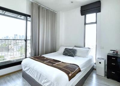 Spacious modern bedroom with large windows and city view