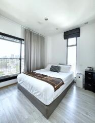 Spacious modern bedroom with large windows and city view