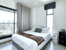 Spacious modern bedroom with large windows and city view