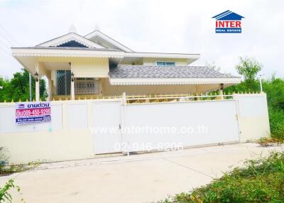 Front view of a house with a gated fence and landscaping