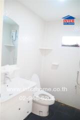 White bathroom with sink, toilet, and shower