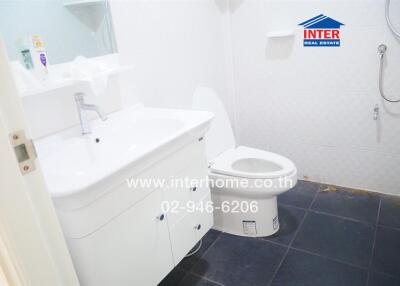 Modern bathroom with white fixtures and dark floor tiles