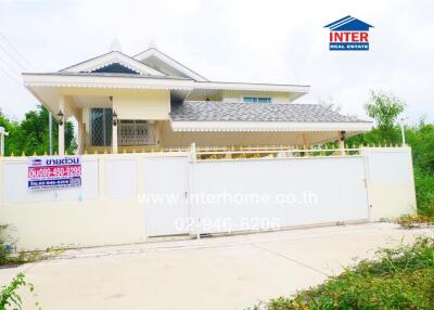 Two-story residential building with white exterior and gated entrance