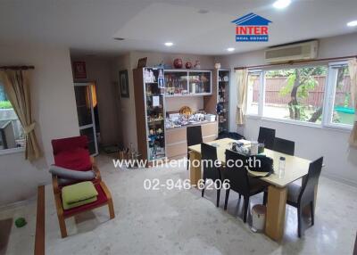 Dining area with a table set for six, shelves, and large windows providing natural light