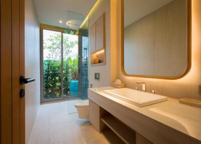 Modern bathroom with large mirror and vanity, glass shower door, and natural lighting