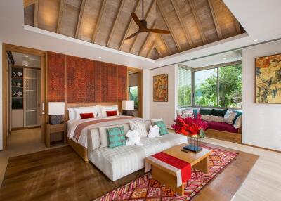 Luxurious bedroom with wood ceiling, large bed, and cozy seating area