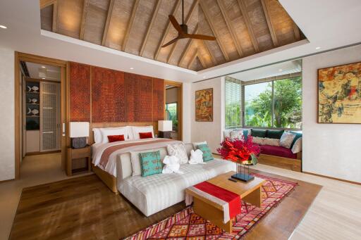 Luxurious bedroom with wood ceiling, large bed, and cozy seating area