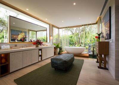 Luxurious bathroom with large mirror and a view of greenery