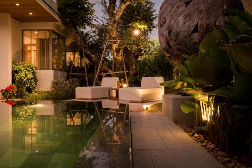 Outdoor seating area with pool and night lighting