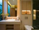 Modern bathroom with large mirror, sink, toilet, and glass shower