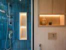 Modern bathroom with blue tiled shower and wooden storage shelves