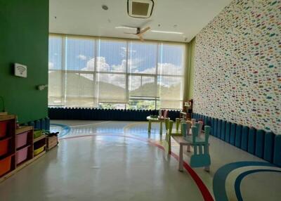 A spacious indoor play area with large windows and vibrant decor.