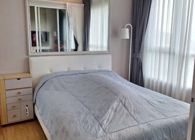 Bedroom with a bed, large mirror, and window with curtains