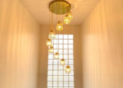 Staircase with modern chandelier and glass block window