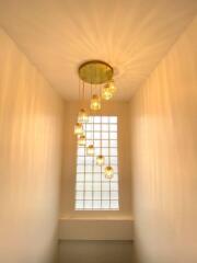 Staircase with modern chandelier and glass block window