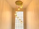 Staircase with modern chandelier and glass block window