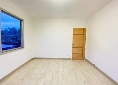 Minimalist empty bedroom with wooden flooring and single window