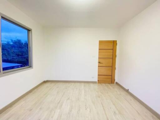 Minimalist empty bedroom with wooden flooring and single window