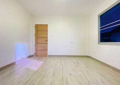 Empty bedroom with wooden door and large window