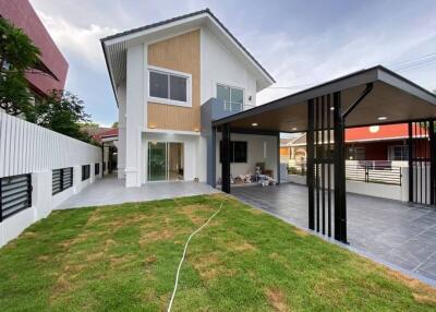 Front view of a two-story house with a garage and garden