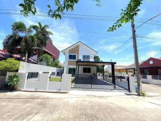 Front view of a modern two-story house with a driveway and a yard