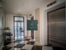 Elevator lobby area with two elevators and decorative floor