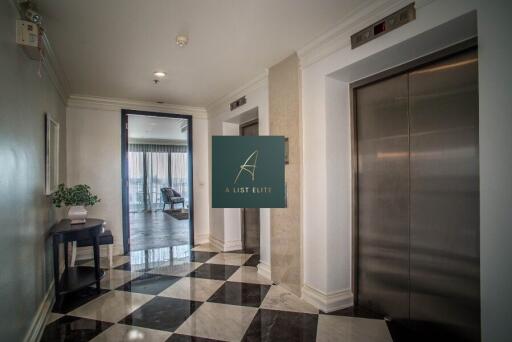 Elevator lobby area with two elevators and decorative floor