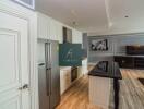 Modern kitchen and living room with stainless steel appliances and flat screen TV