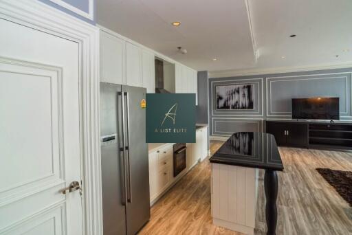 Modern kitchen and living room with stainless steel appliances and flat screen TV